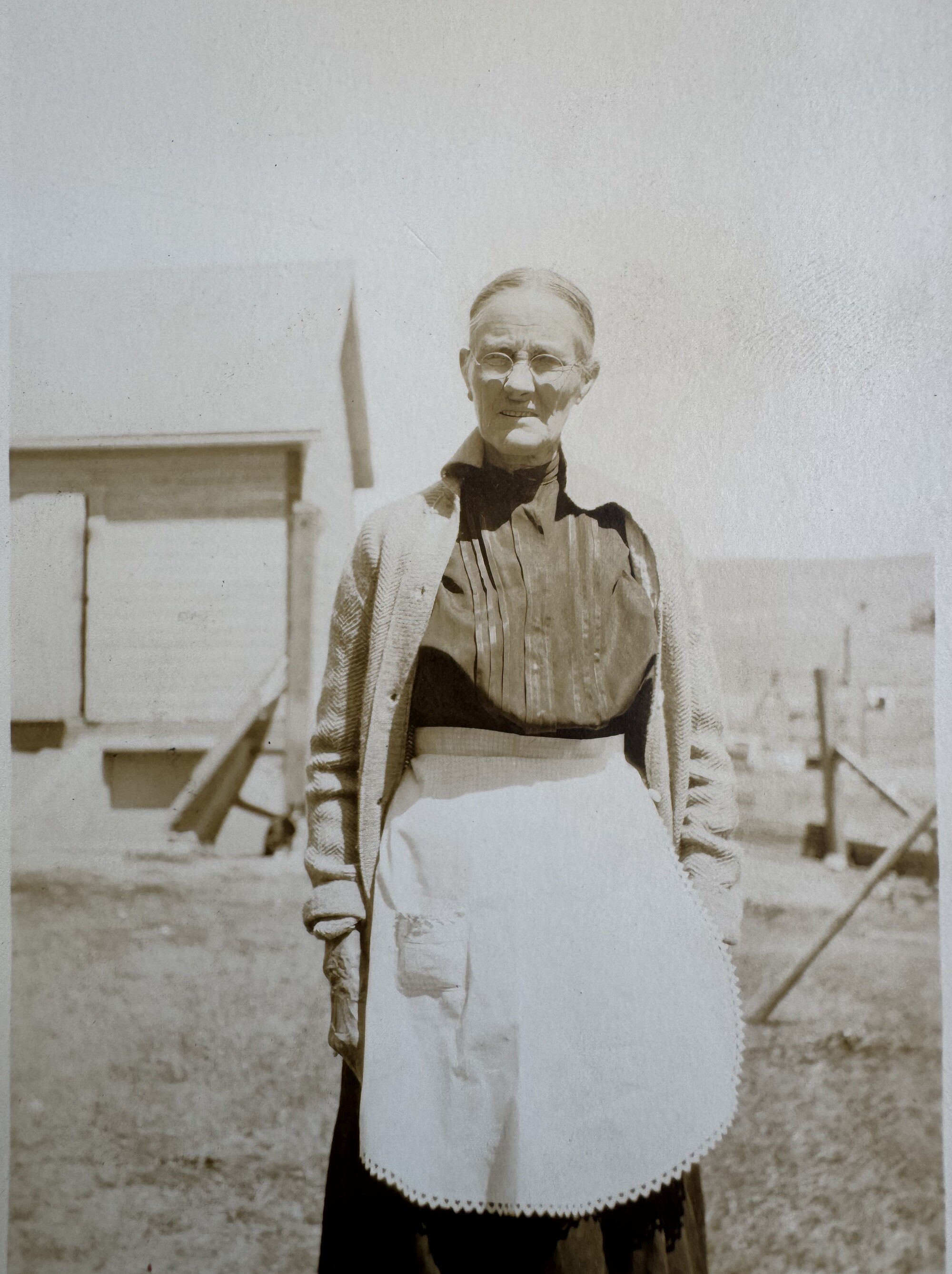Woman in an apron standing in the farmyard